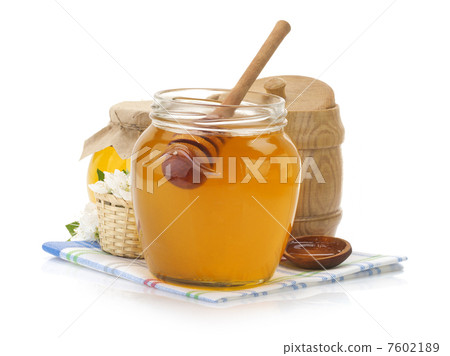 glass jar full of honey and stick 7602189