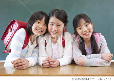 微笑在黑板前面的三個小學女孩 7612544