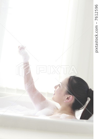 洗她的身體的婦女與泡沫浴 7612596