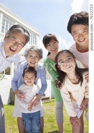 Three generations of parent and child smiling in the garden 7612723