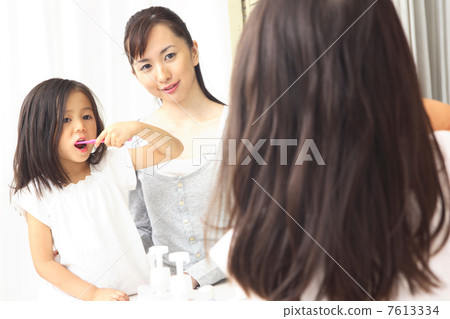 Girls brushing teeth and their mothers 7613334