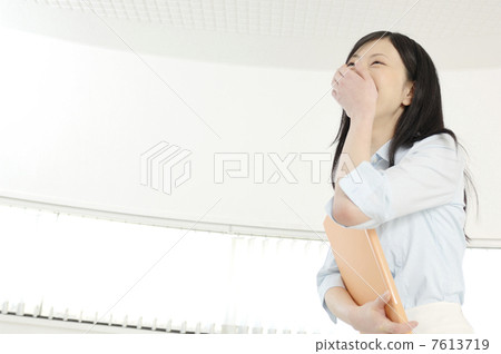 A woman laughing while holding a file 7613719