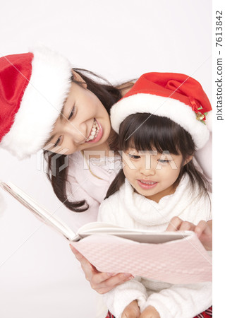 Mother reading a book to her daughter 7613842