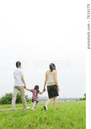 A rear view of the family walking along the river 7614279