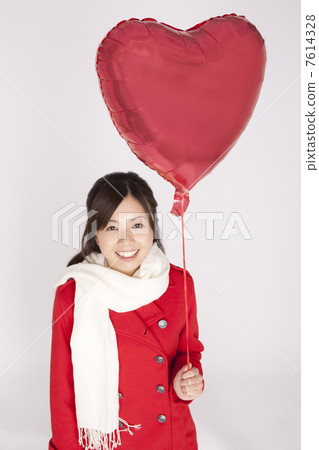 A woman with a heart balloon A woman with a heart balloon 7614328