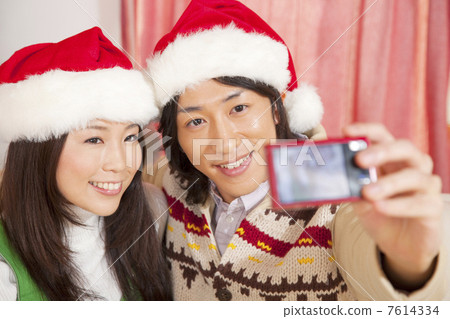 A couple photographing themselves with digital cameras at Christmas A couple photographing themselves with digital cameras at Christmas 7614334
