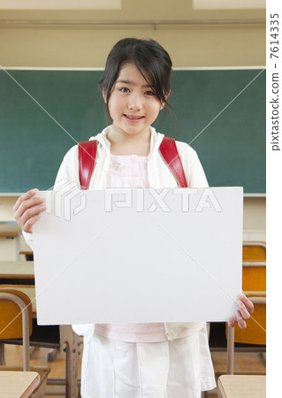 Elementary school student with a message board in the classroom Elementary school student with a message board in the classroom 7614335