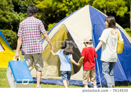 A family walking by hand at a campsite 7614830