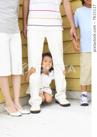 一個女孩躲在他父親的腳後面 7615117