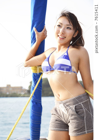 A woman standing in front of a yacht 7615411