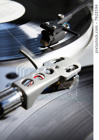 Turntable playing vinyl record with music 7628594