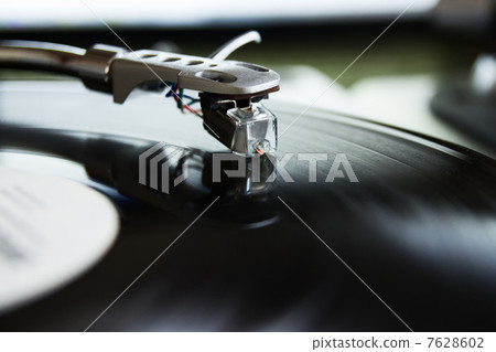 Turntable playing vinyl record with music 7628602