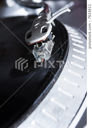 Turntable playing vinyl record with music 7628611