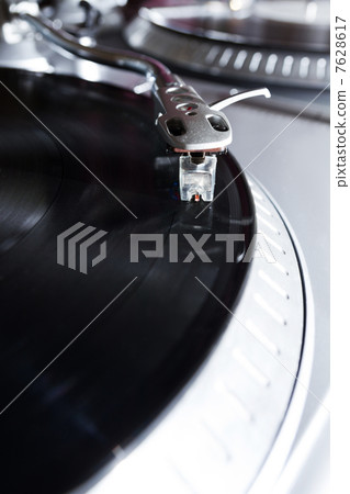 Turntable playing vinyl record with music 7628617