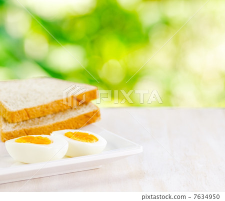 Boiled eggs and toasts on white table 7634950