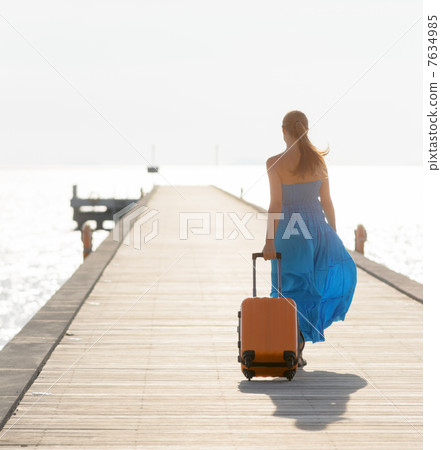 Young woman walking on wooden pier Young woman walking on wooden pier 7634985