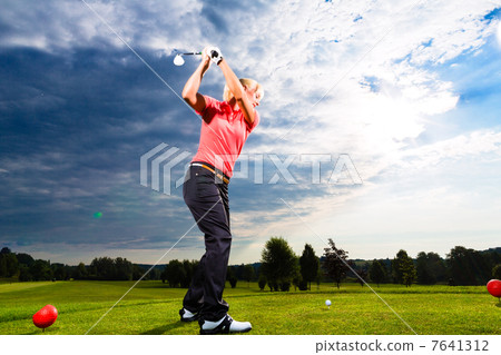 Young golf player on course doing golf swing Young golf player on course doing golf swing 7641312