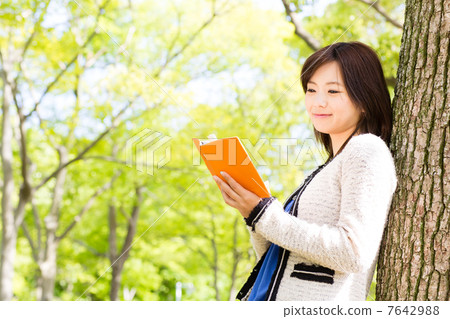 A woman reading in the park 7642988