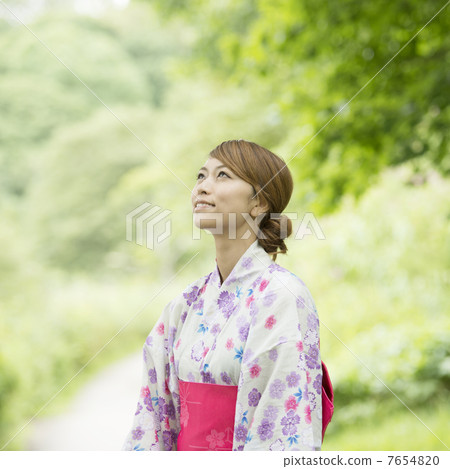 A woman in a yukata looking up at the sky A woman in a yukata looking up at the sky 7654820