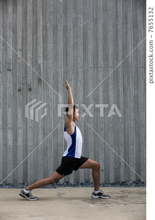Sporty Young Asian man stretching outdoors in urban city. 7655132
