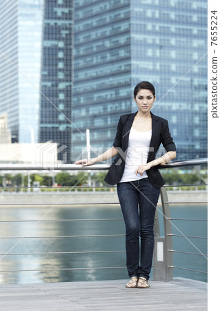 Business woman standing in front of office building 7655224