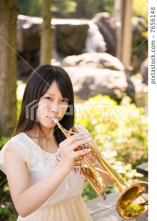 一個女人坐在樹蔭下吹喇叭 一個女人坐在樹蔭下吹喇叭 7656148