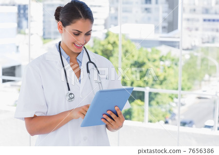 Smiling young doctor using tablet pc 7656386