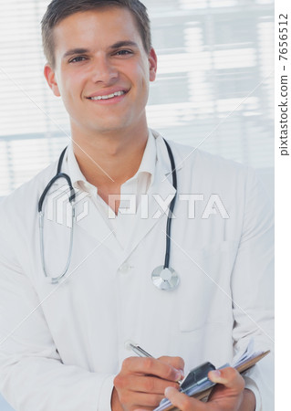 Handsome doctor holding pen Handsome doctor holding pen 7656512