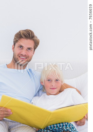 Portrait of a father reading a story to his son 7656659
