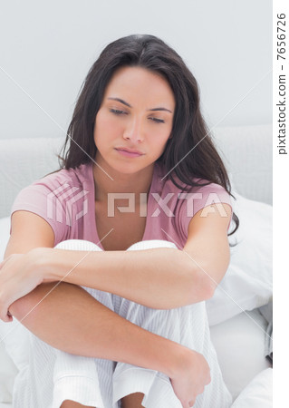 Anxious woman sat on her bed Anxious woman sat on her bed 7656726