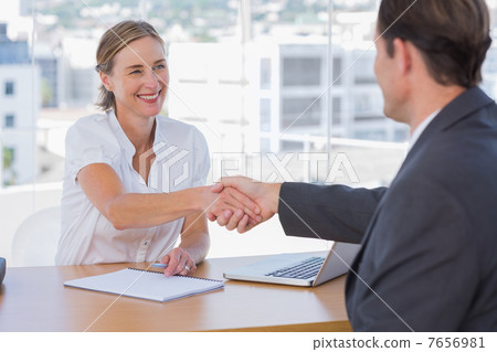 cheerful interviewer shaking hand of an interviewee 7656981