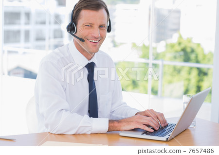 Cheerful businessman wearing a headset Cheerful businessman wearing a headset 7657486