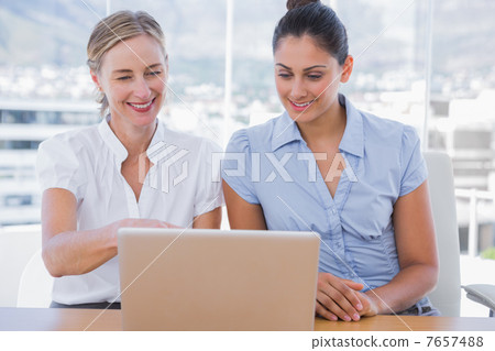 Businesswomen looking at laptop Businesswomen looking at laptop 7657488