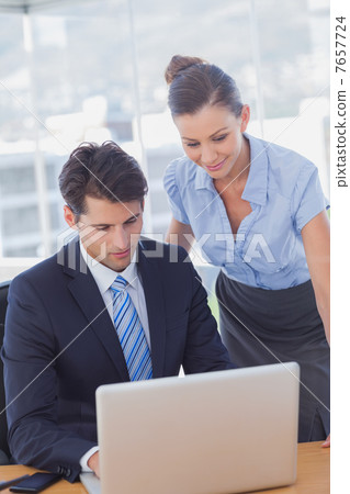 Business people smiling and working together with a laptop Business people smiling and working together with a laptop 7657724