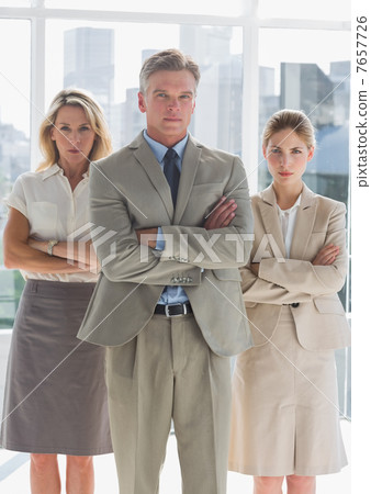 Three serious business people standing together Three serious business people standing together 7657726
