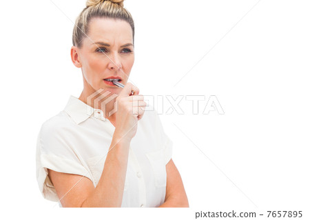 Focused businesswoman with pen on mouth Focused businesswoman with pen on mouth 7657895