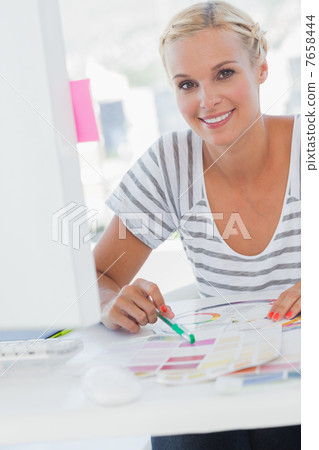 Pretty interior designer pointing at colour charts Pretty interior designer pointing at colour charts 7658444