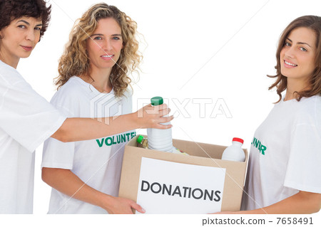 Volunteer women putting food in donation box 7658491