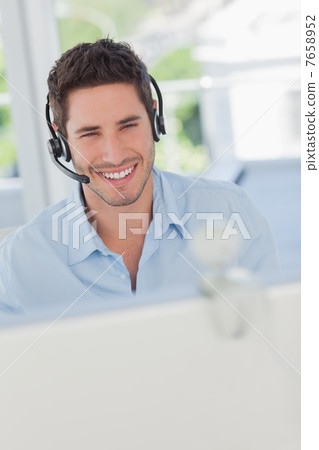 Cheerful designer having a video chat in his office 7658952