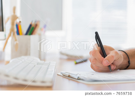 Close up of a hand writing in a modern office 7659738