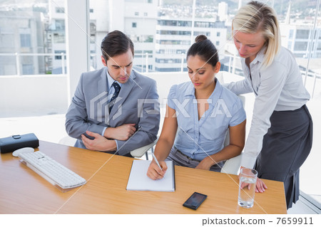 Businesswoman showing colleagues something on her notepad 7659911