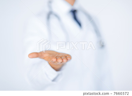 male doctor holding something in his hand 7660372
