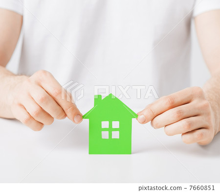 hands holding green house 7660851