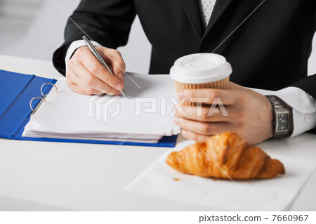 businessman with coffee writing something businessman with coffee writing something 7660967
