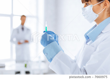 female doctor holding syringe with injection female doctor holding syringe with injection 7660975