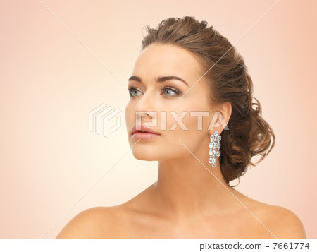 woman wearing shiny diamond earrings 7661774