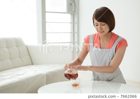 A woman putting tea 7662066
