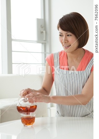 A woman putting tea 7662096