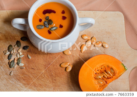 Pumpkin vegetable cream soup in white bowl with piese pumpkin 7663359
