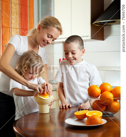 Mother with children squeezed orange juice Mother with children squeezed orange juice 7666706